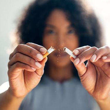 Woman breaking cigarette in half