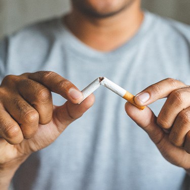 Man breaks cigarette