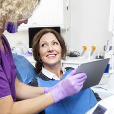 dentist showing a patient information on a tablet