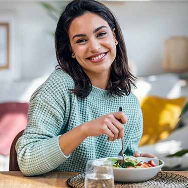 Woman smiling eating salad