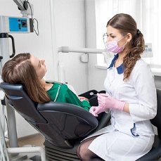 A female dentist speaking with a patient about her dental injury 