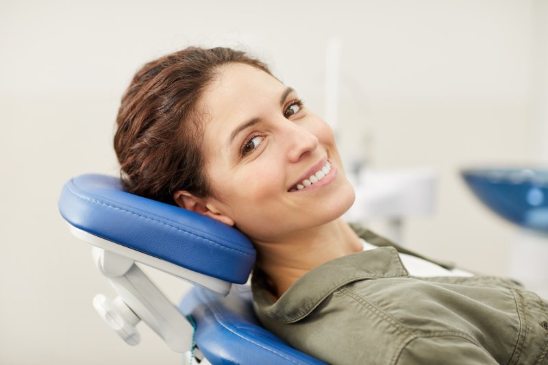 person smiling after having chipped tooth repaired at the dentist