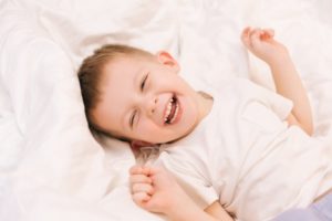 Baby smiling while lying in bed