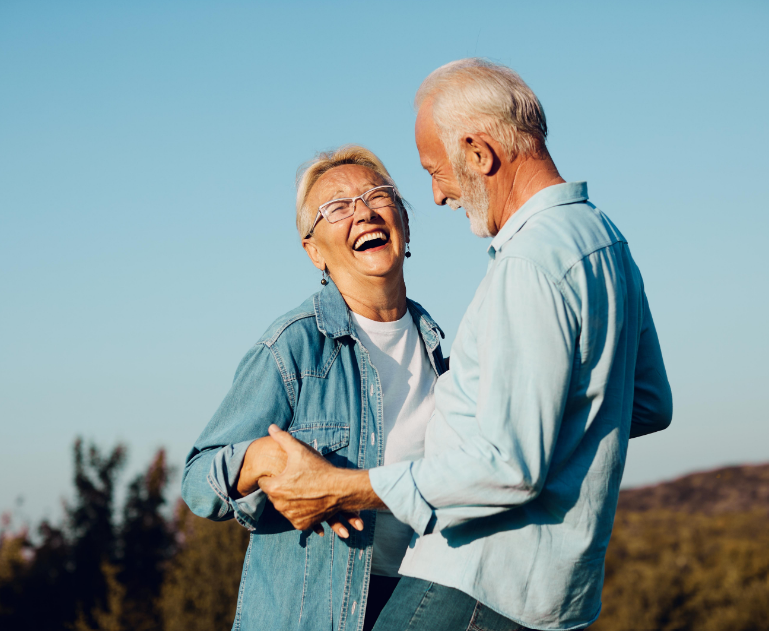 Senior couple smiling and dancing outside